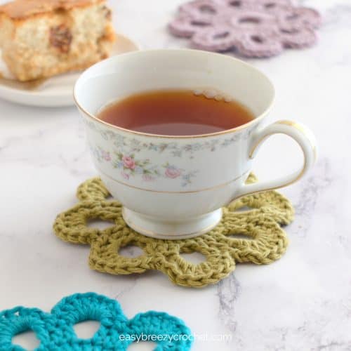 A teacup on a flower crochet coaster.