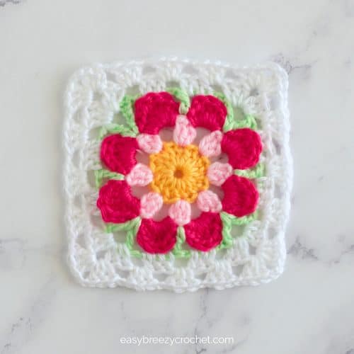 A pink. green and white floral granny square.