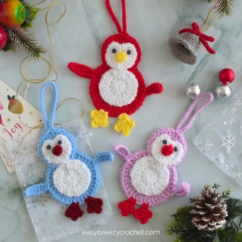 Blue, red and lilac penguin shaped crocheted Christmas decorations.