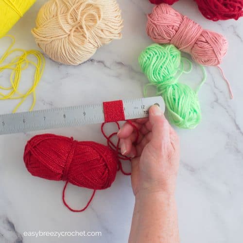 Red yarn wrapped around a ruler.