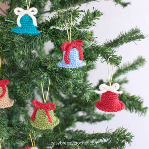 Multi colored crochet crochet bells decorating a tree.