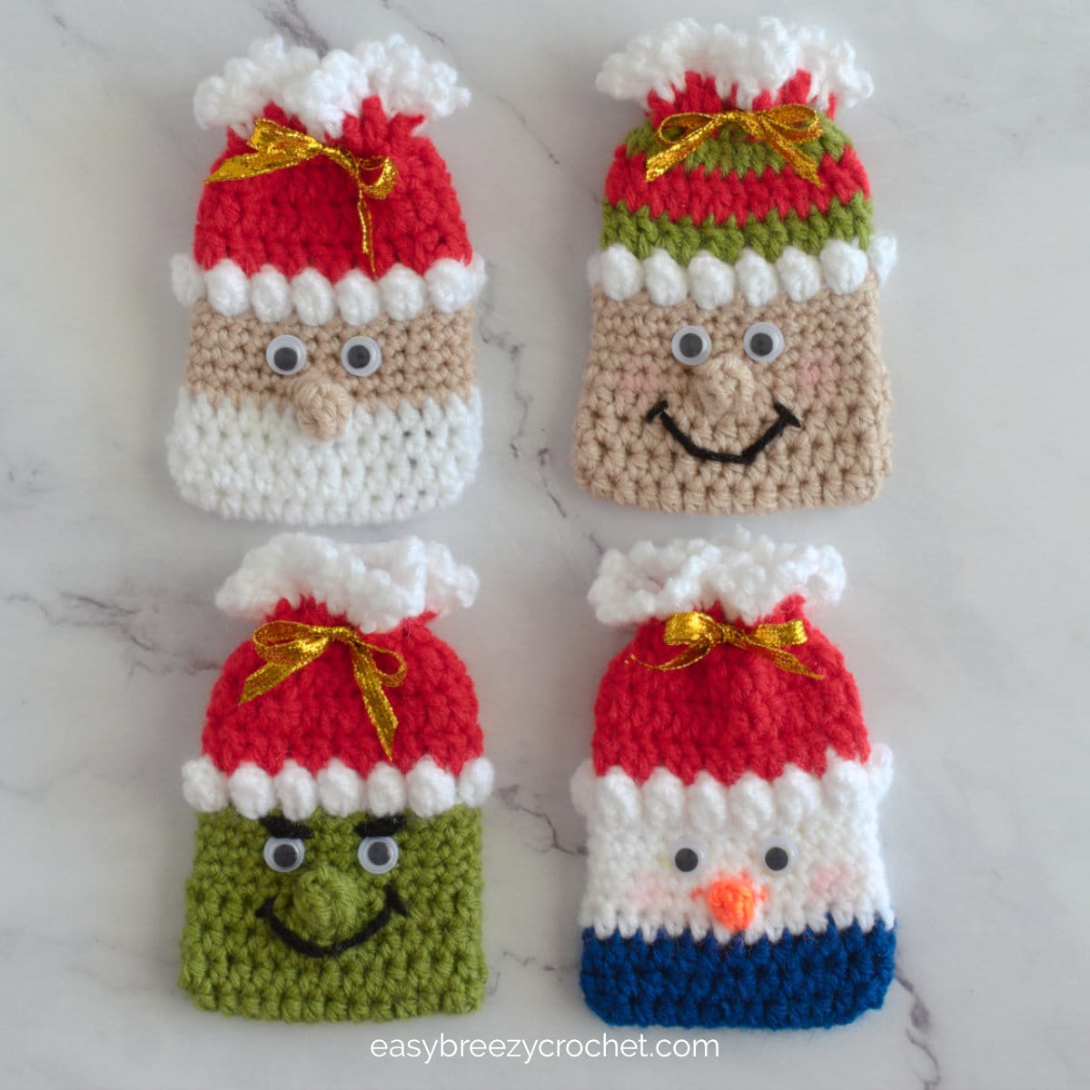 Four crochet Christmas card holders in different designs, a Santa, Snowman, Grinch and Elf.