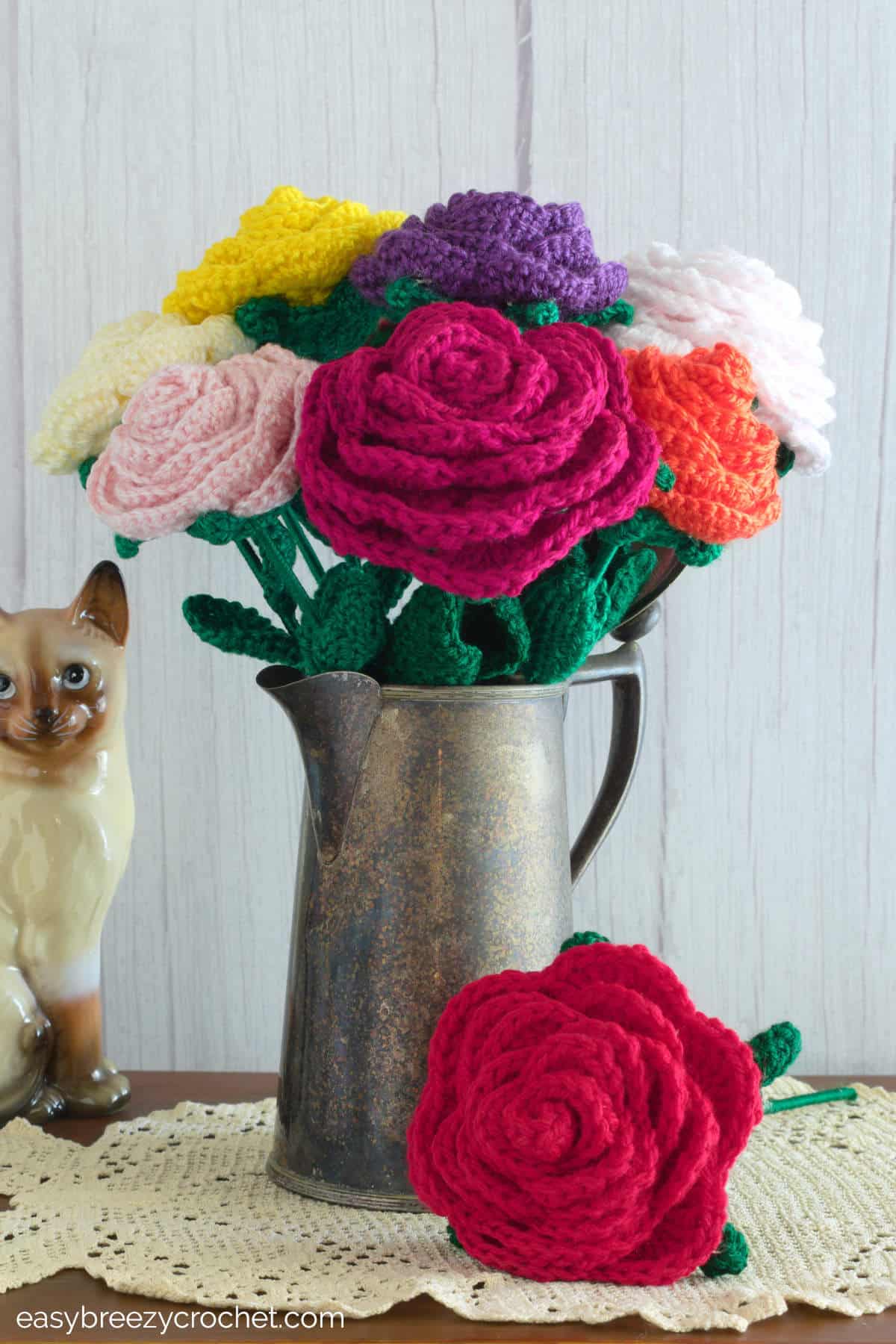Crochet roses in a metal coffee pot.