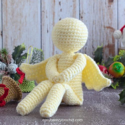 A white faceless sitting crochet angel.