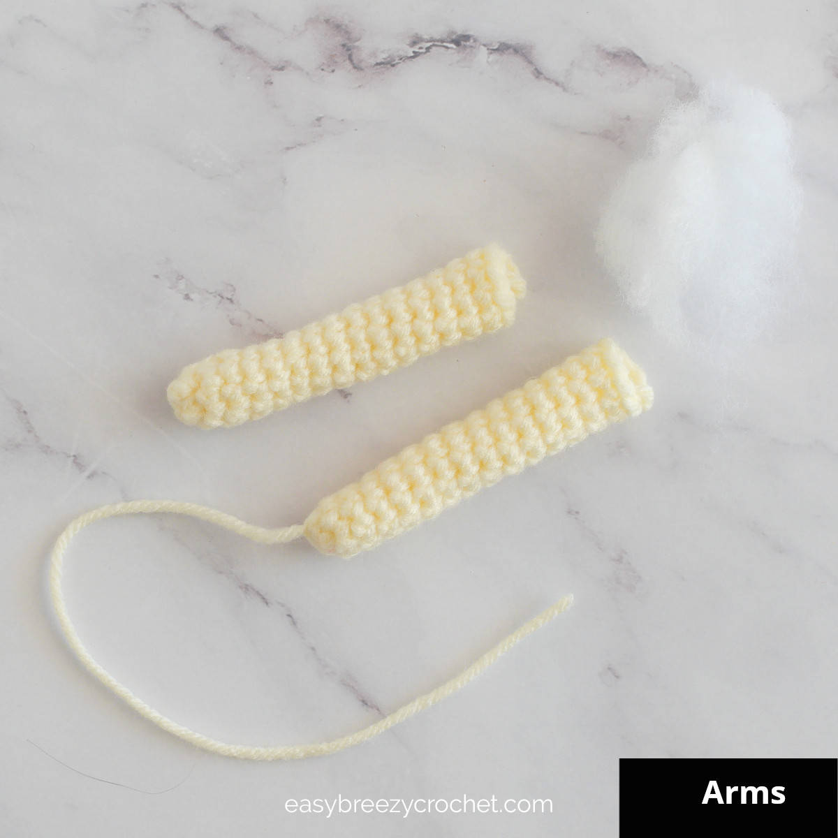 Image of two crocheted arms and toy stuffing.