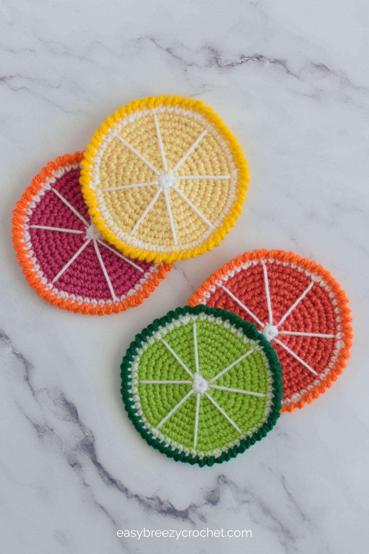 A top down image of four citrus crocheted coasters.
