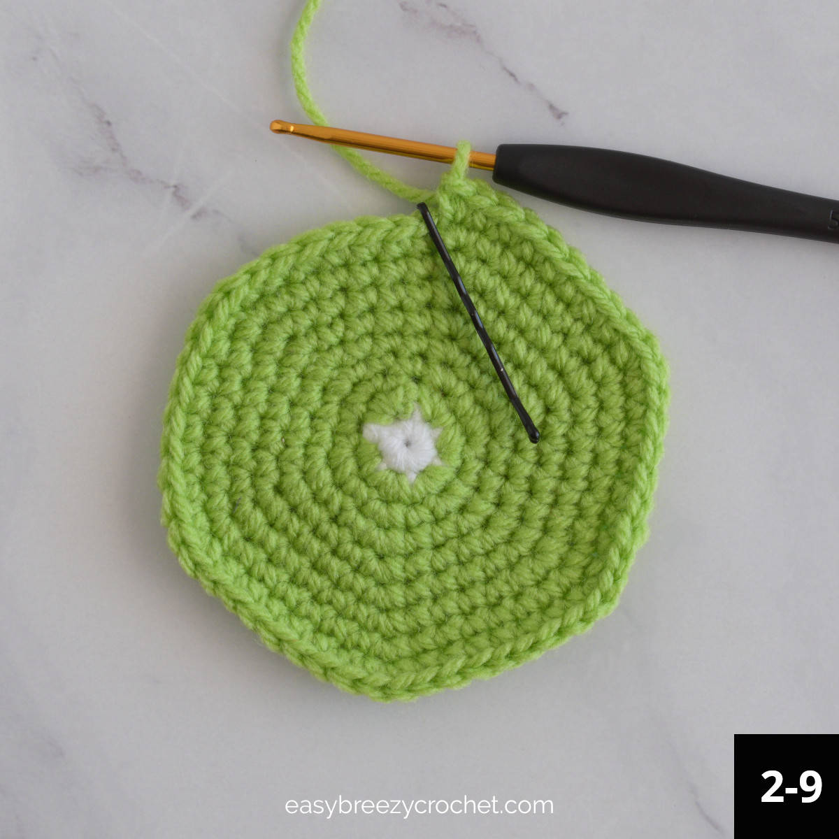 A green crochet circle with a small white centre.