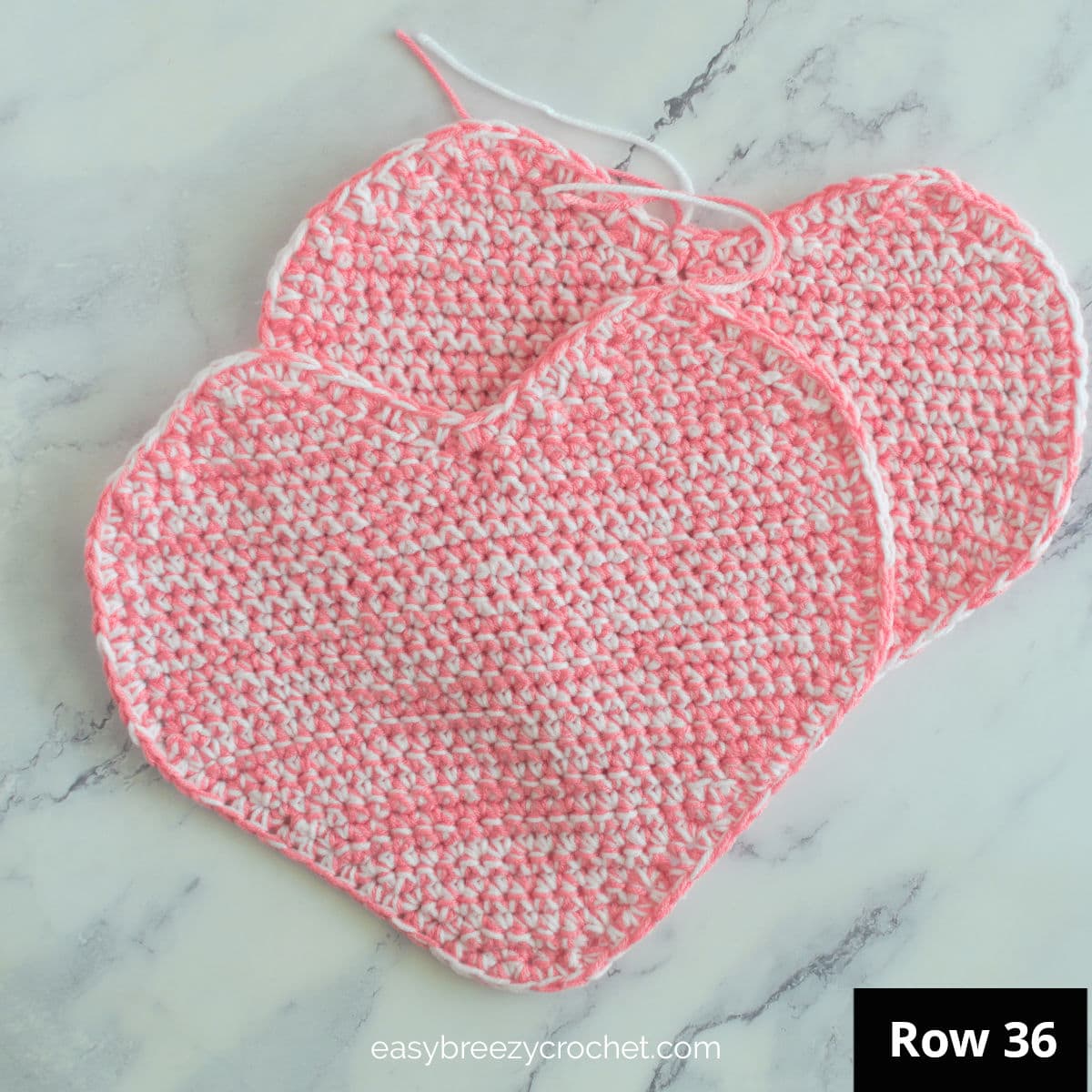 Two complete halves of a crochet heart cushion.
