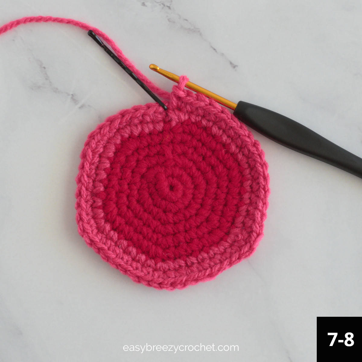 A red and pink crochet circle.