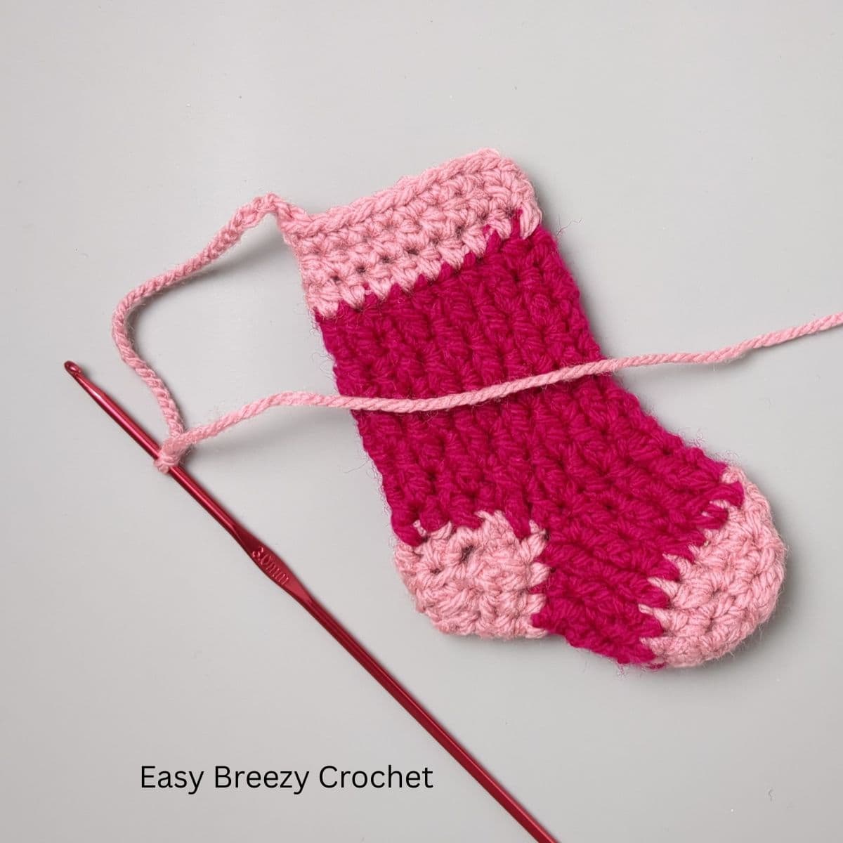A mini crochet stocking with a hanging loop.