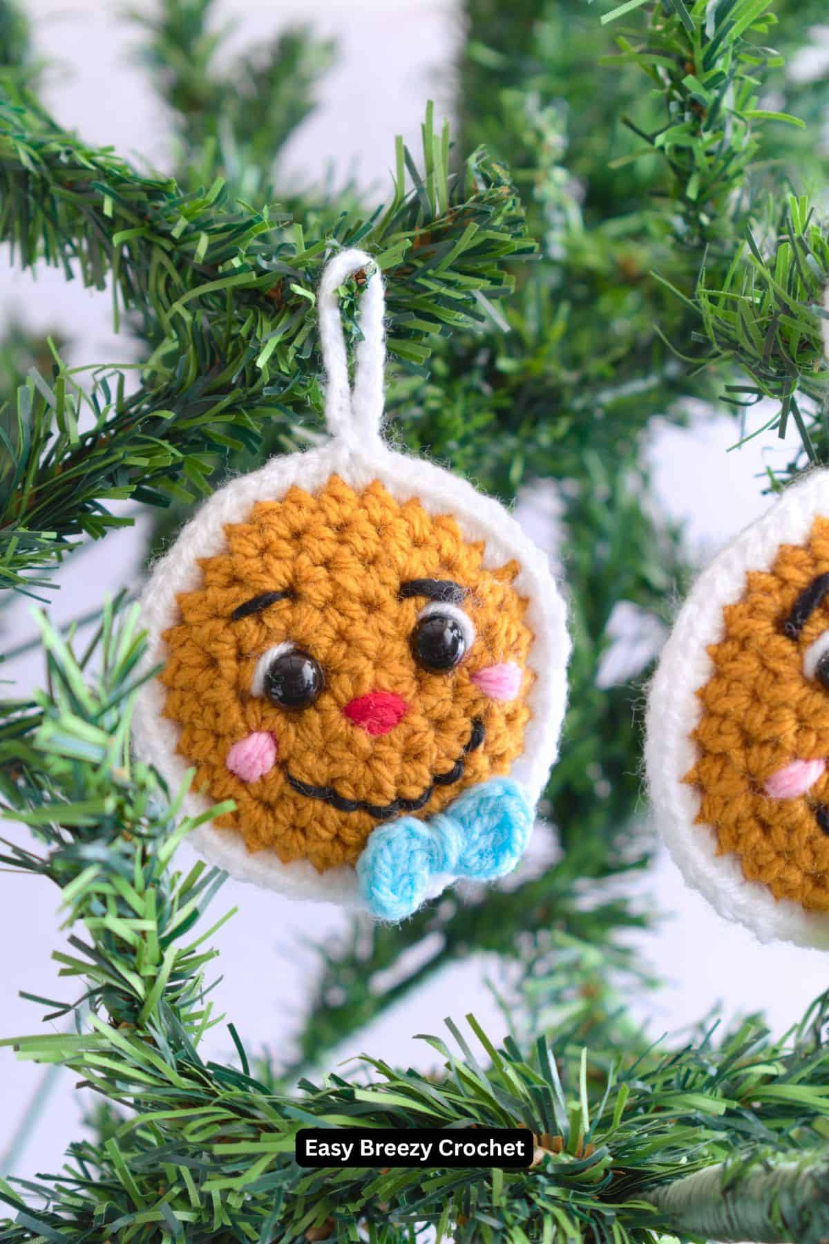 Crochet gingerbread face hanging on Christmas tree.
