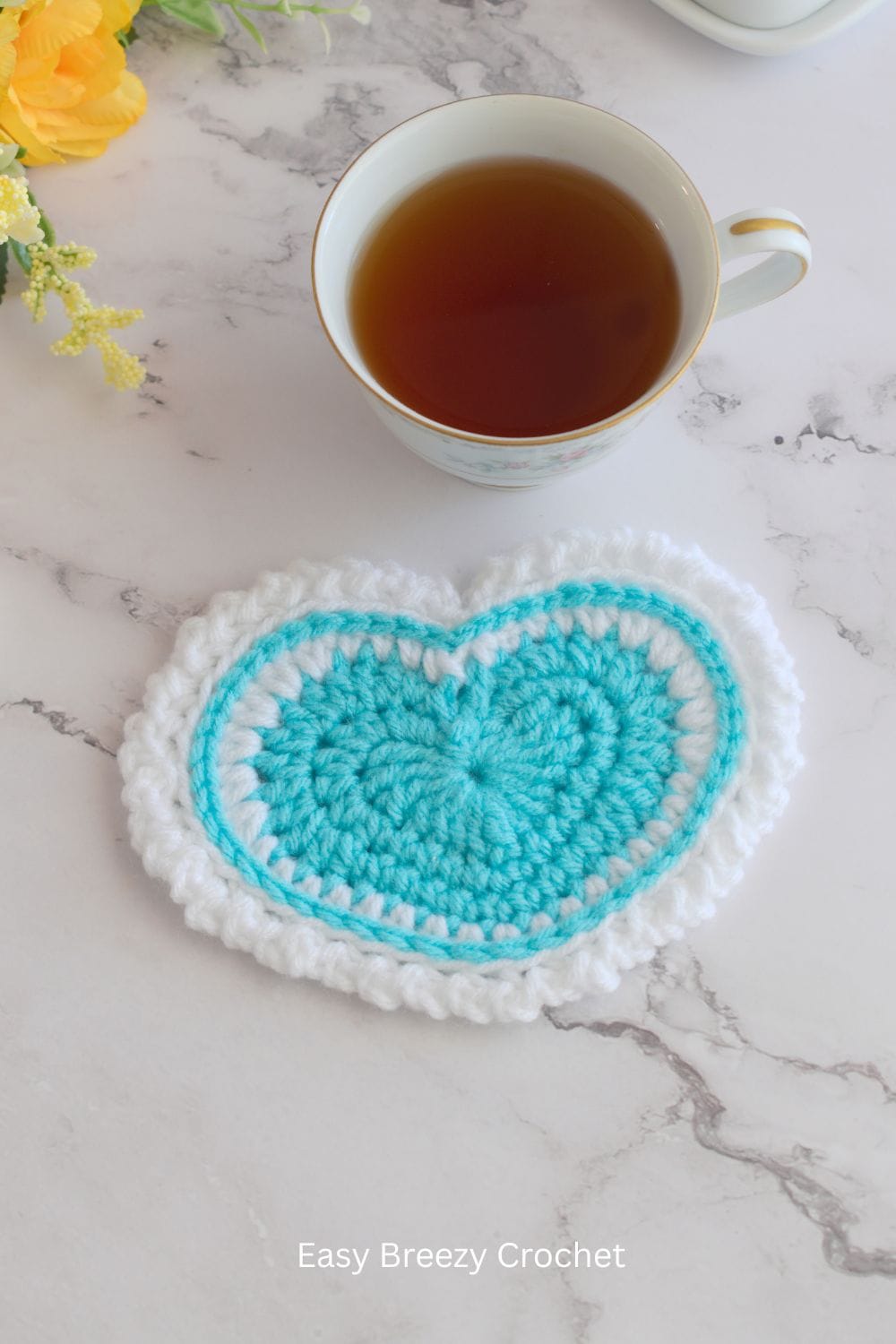Light blue crochet heart coaster.