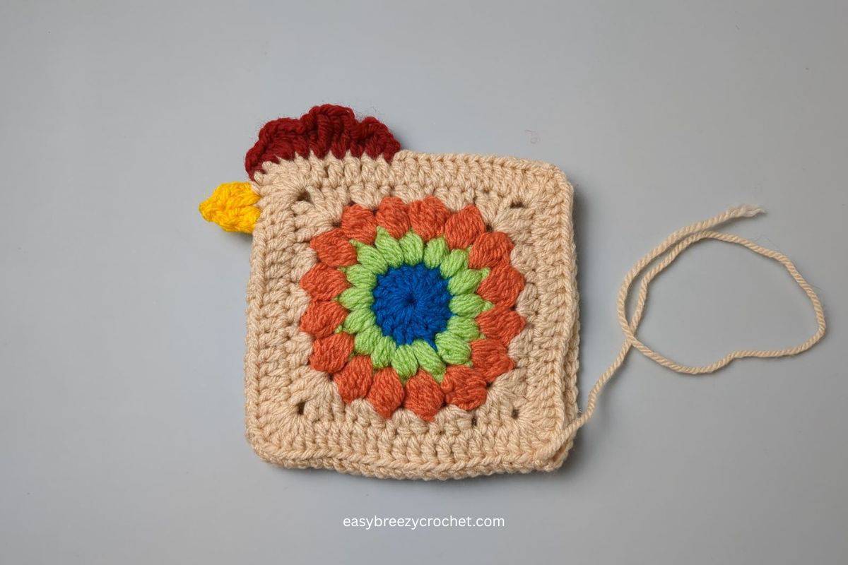Image showing a comb and beak crocheted on the side of a granny square.