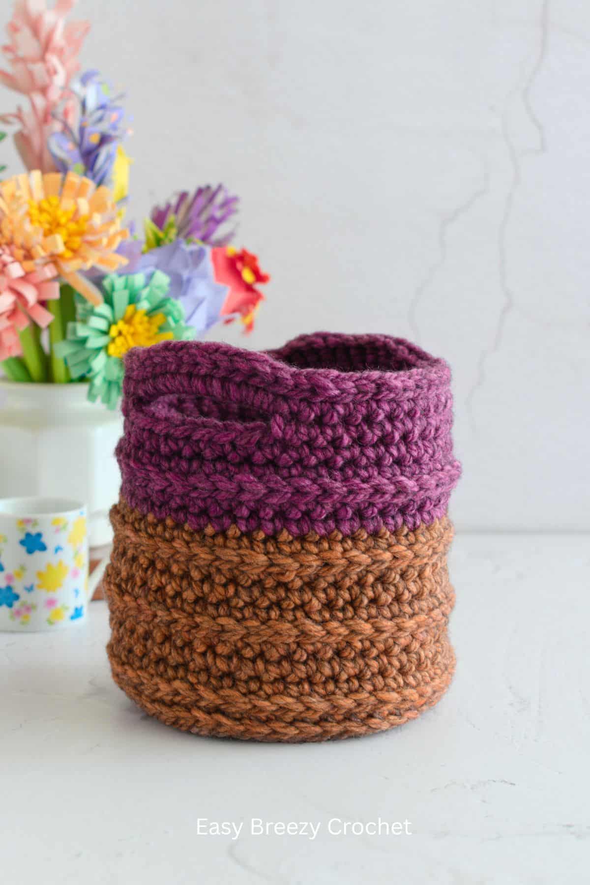 Small round crochet basket with handles.