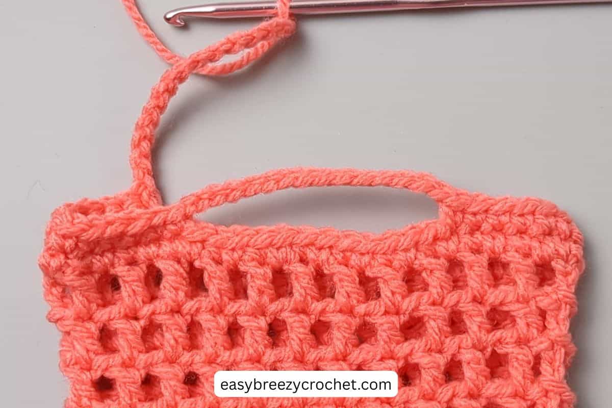Image showing the shaping of crochet handles on a bag.