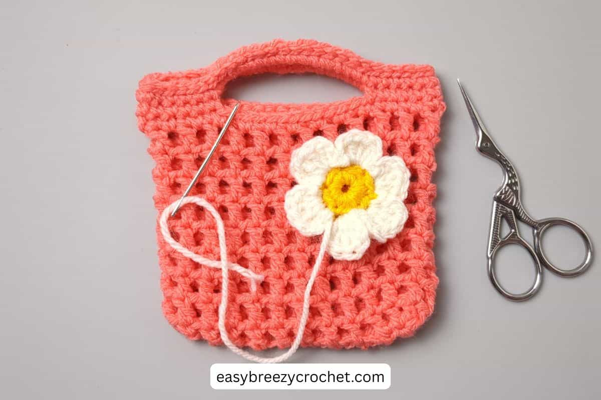 Small crochet bag with a white flower.