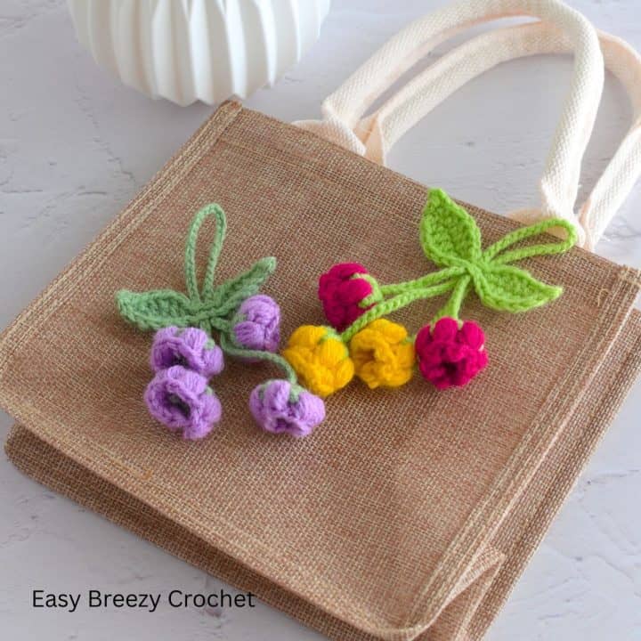 Two flower bag charms placed on a bag.