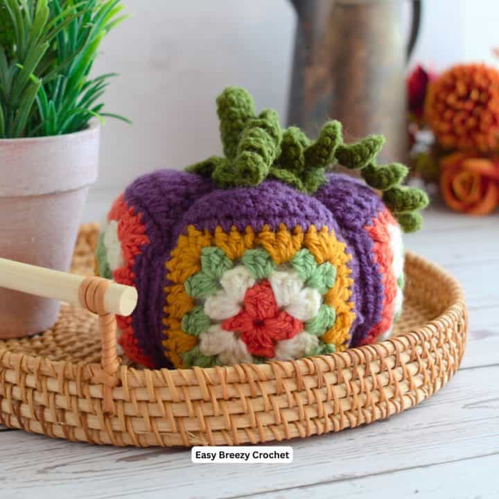 Fall crochet pumpkin on a bamboo tray.