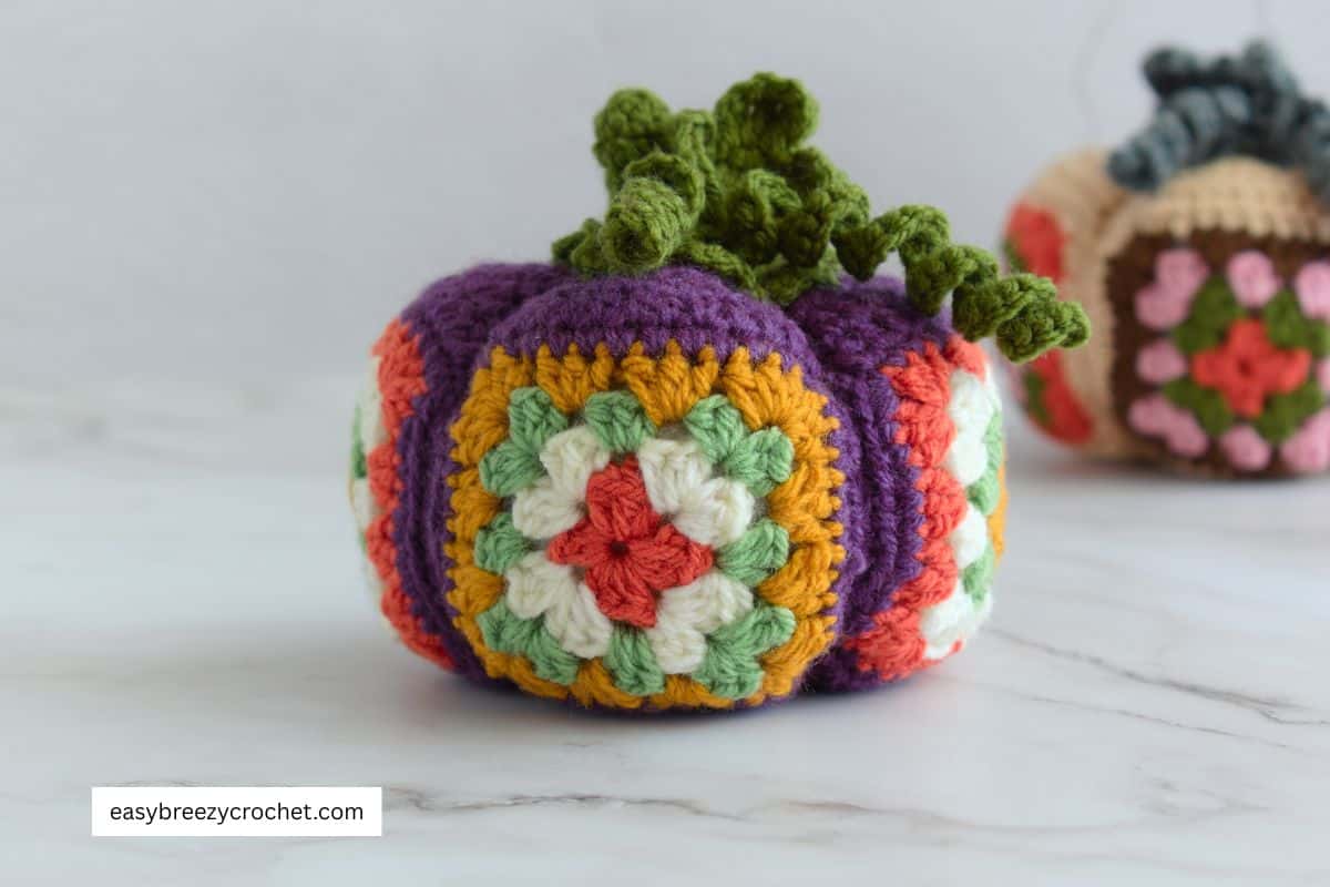 One crochet granny square pumpkin in fall colors.