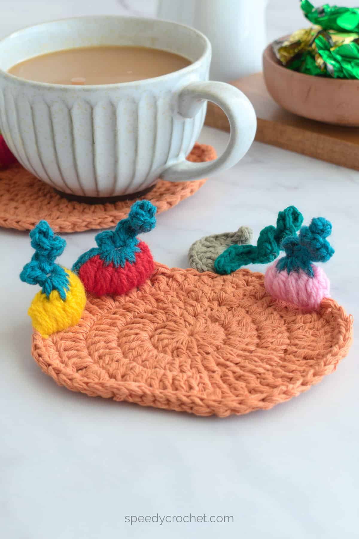 Crochet pumpkin coaster with mini pumpkins.